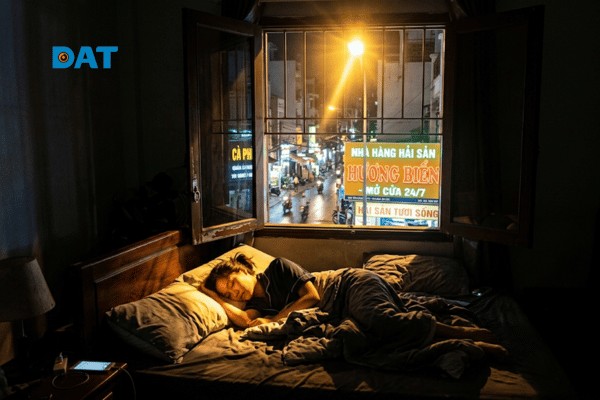 Luồng ánh sáng nhân tạo từ đèn cao áp ngoài đường xâm nhập qua cửa sổ vào không gian phòng ngủ của hộ dân.